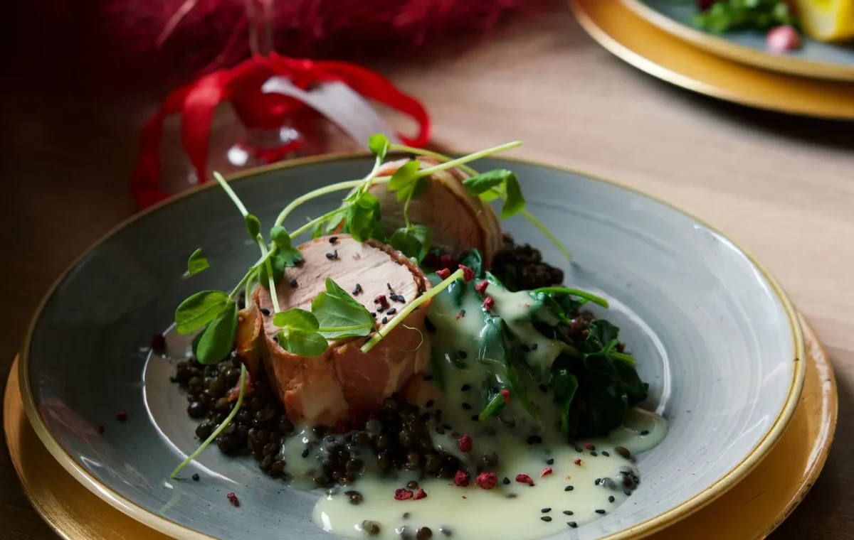 Delicious pork tenderloin with lentils, spinach, and creamy lemon sauce, perfect for a gourmet dinner.