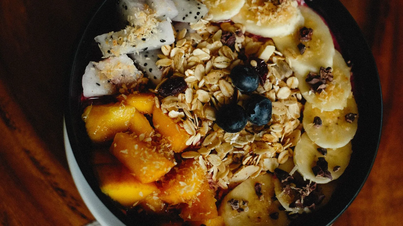 A vibrant breakfast bowl filled with fresh fruits, oats, and granola for a healthy meal.