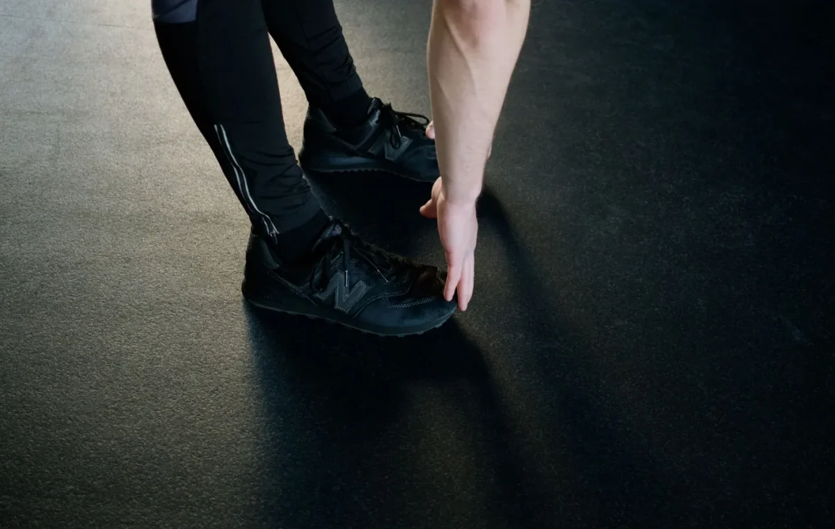 A person stretching in a gym, reaching down to touch their feet. Fitness and exercise concept.
