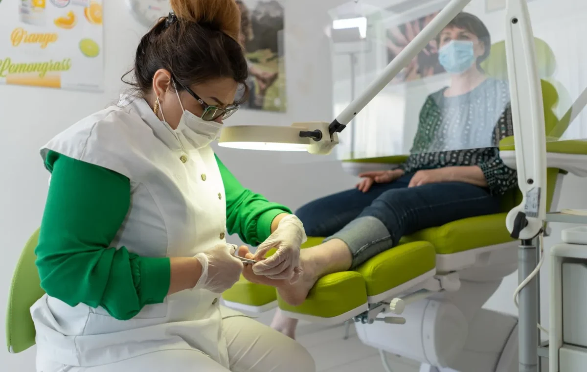 A beautician provides a pedicure in a modern spa setting, focusing on foot care and relaxation.