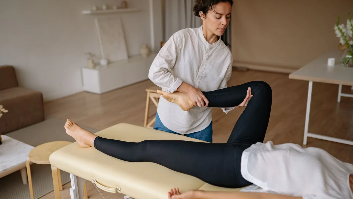 A massage therapist provides a rejuvenating leg treatment in a calming spa environment.