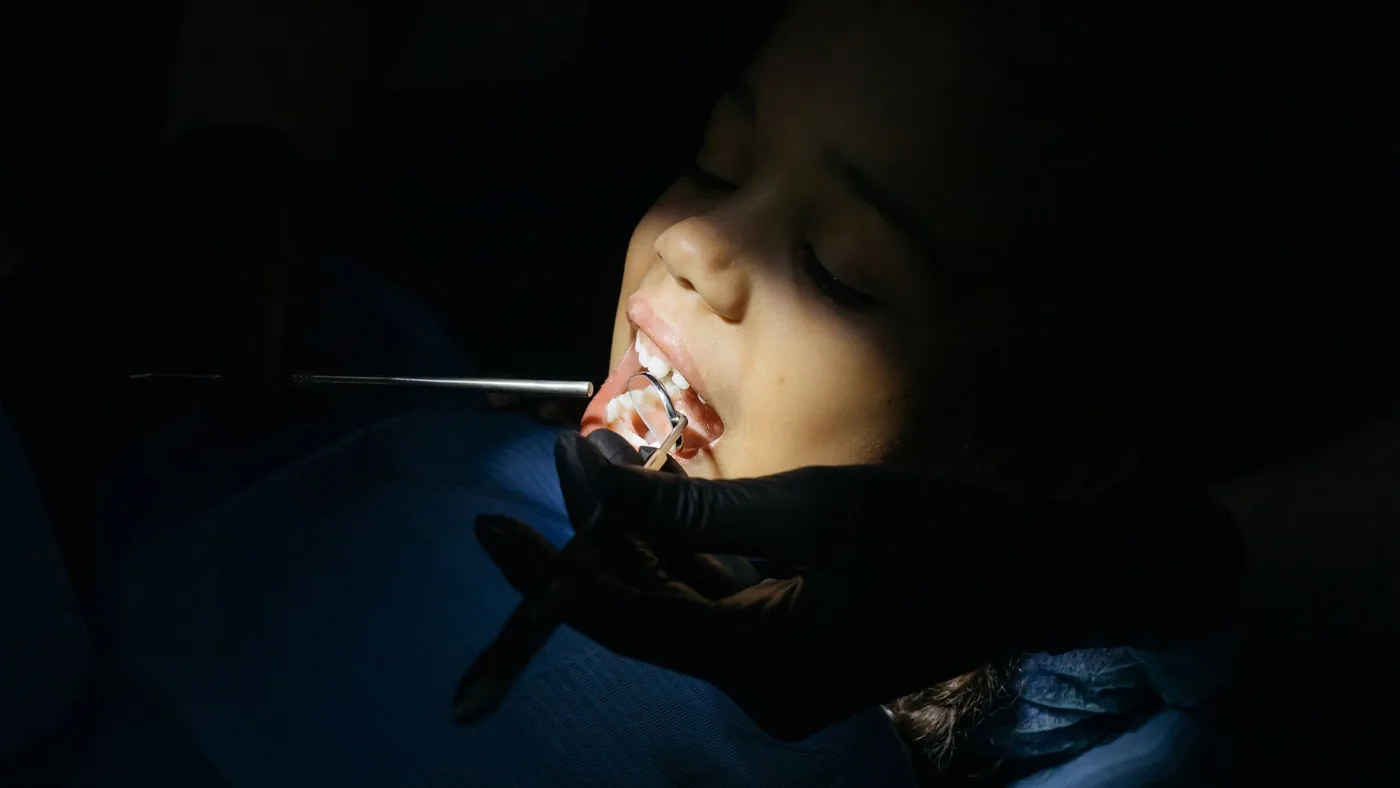 Close-up of a child undergoing a dental exam at a clinic, highlighting dental care procedures.
