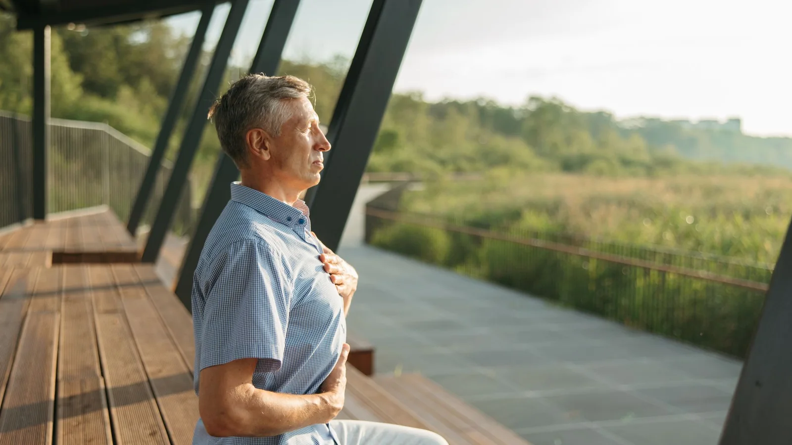Senior man practicing meditation outdoors, embracing peaceful relaxation and mindfulness during daylight hours.