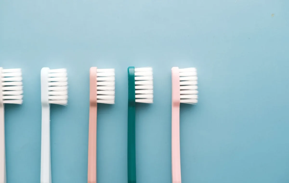A row of five colorful toothbrushes arranged on a blue background, perfect for dental care themes.